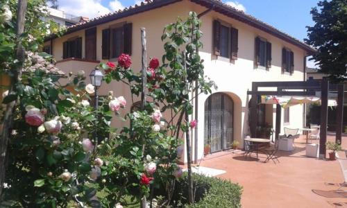 佛罗伦萨Casale dei cento Acri的前面有玫瑰花丛的房子