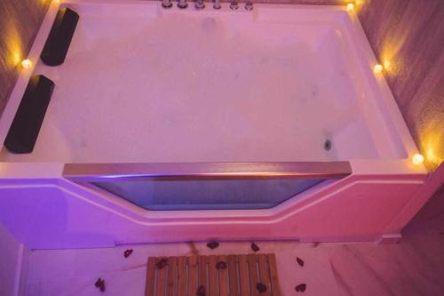 阿尔卡拉德尔胡卡尔LOFT TÚ y YO的粉红色的浴缸上方有灯
