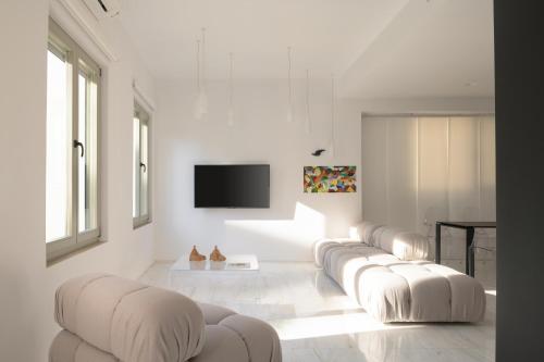 罗希姆诺TWO VAULTS, Rethymno old town的客厅配有一排白色沙发