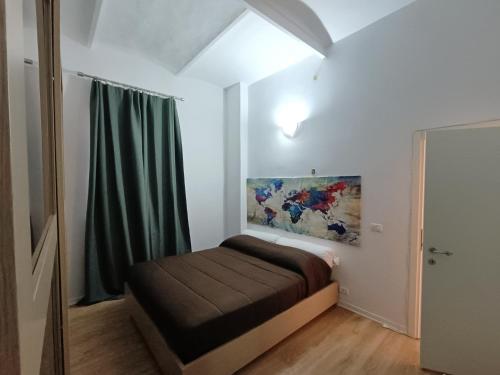 博洛尼亚Suite Del Parco的卧室配有一张床,墙上挂有绘画作品