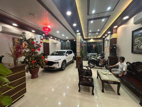 顺化Đức Lộc 2 Hotel的坐在客厅里的人,有车