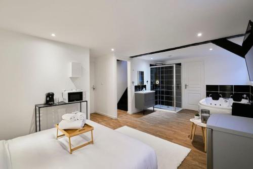 图尔昆NG SuiteHome - Lille l Tourcoing l Haute - Duplex 4 pers - Balnéo - Netflix - Wifi的客厅配有白色沙发和水槽