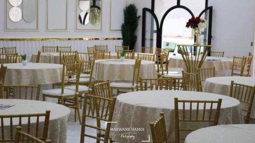 泰塔温hotel amilcar tataouine的一间设有桌椅和白色桌布的房间