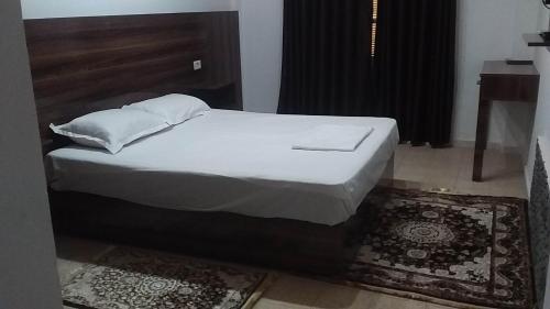泰塔温hotel amilcar tataouine的一张带白色床单和枕头的床