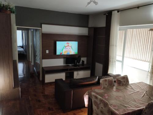 南卡希亚斯Apto central completo perto de tudo的带沙发和平面电视的客厅