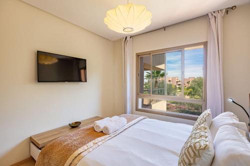 马拉喀什Golf Prestigia, grande piscine, jardins的一间卧室设有一张床和一个大窗户