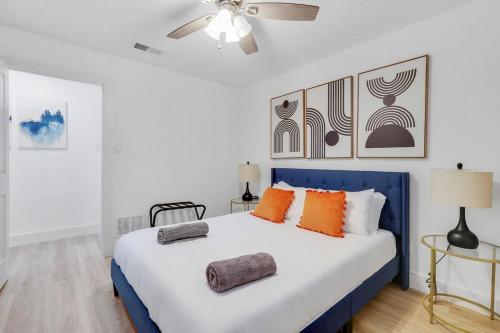 达拉斯Cozy 4 bedroom home with hot tub galleria location的卧室配有蓝色和白色的床以及橙色枕头
