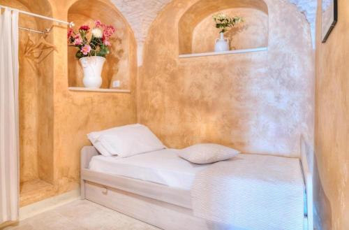 洛科罗通多Casa vinci的墙上有两瓶花的一个小床