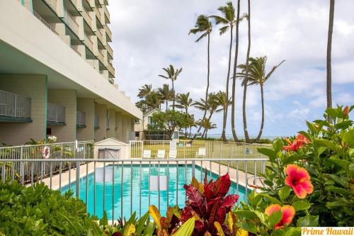 拉耶Beautiful Beachfront Condo的棕榈树建筑前的游泳池