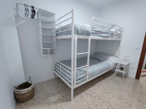 卡马斯Precioso apartamento en Sevilla.的白色客房内的白色双层床