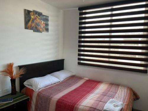 奥塔瓦洛Hostal Aly的一间卧室设有一张床和一个大窗户