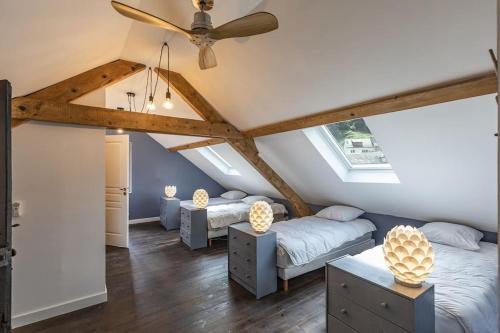 EsterreSuperbe villa familiale - 1408的阁楼卧室配有两张床和吊扇