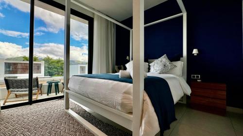 塔马兰Villa familiale avec piscine的一间卧室设有一张蓝色墙壁的床和一个阳台。