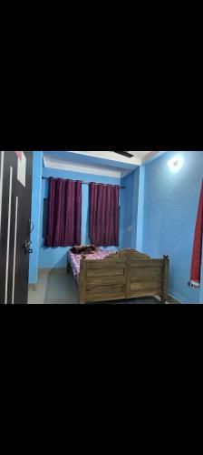 德奥加尔MAA MANSHA GUEST HOUSE的一间卧室设有木床和2个窗户。