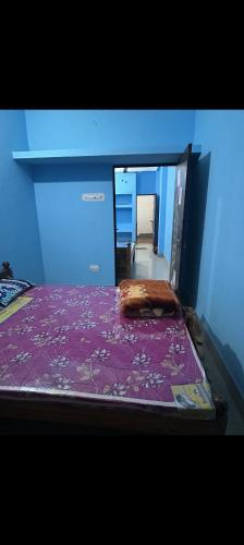 德奥加尔MAA MANSHA GUEST HOUSE的一间卧室配有一张带紫色床罩的床