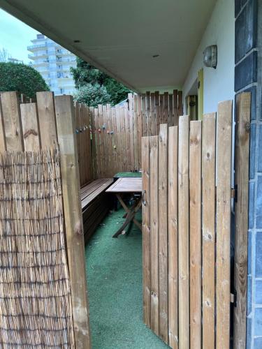 巴约讷Appartement T2 Bayonne-Anglet的木栅栏,带野餐桌和长凳