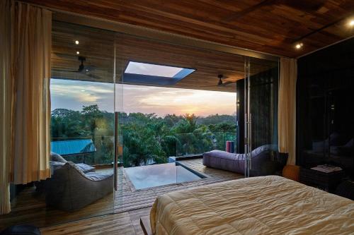 圣塔特蕾莎海滩SELVA RESORT Ocean View Luxury Villas的一间卧室设有一张床和一个大型玻璃窗