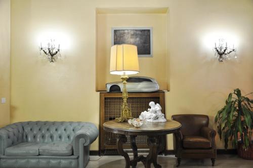 米兰圣桂多酒店的客厅配有沙发和带台灯的桌子