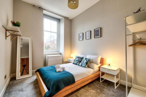 格拉斯哥Stylish & Spacious 3 Bedroom Apt in Finnieston, West End的一间卧室设有一张大床和一个窗户。