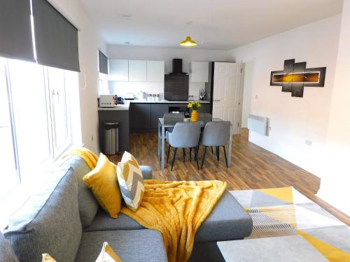 汉密尔顿Newly refurbished 2 bedroom apartment close to station and local amenities的客厅以及带沙发和桌子的厨房。