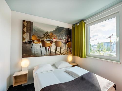 莱茵河畔威尔B&B Hotel Weil am Rhein/Basel的一间卧室设有一张床和一个大窗户