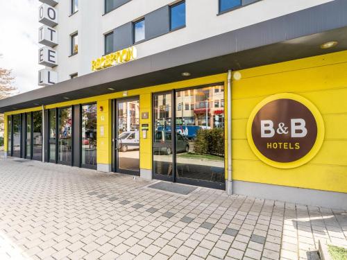 莱茵河畔威尔B&B Hotel Weil am Rhein/Basel的黄色建筑,有bb酒店