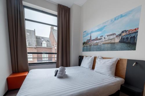 马斯特里赫特easyHotel Maastricht City Centre的一间卧室设有一张床和一个大窗户