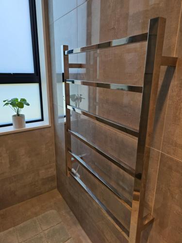 SilverdaleTui Nest Garden Unit的带淋浴的浴室(带木墙)