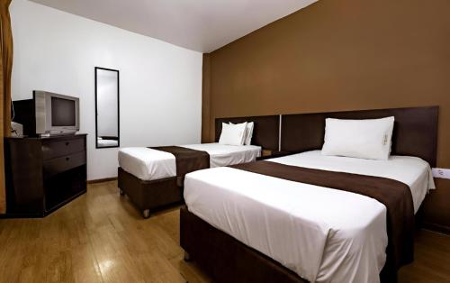 特鲁希略El Centurión的酒店客房设有两张床和电视。