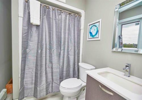 尼亚加拉瀑布Luxury Boutique 2 Bedroom Condo - 1B的浴室设有卫生间、水槽和淋浴帘
