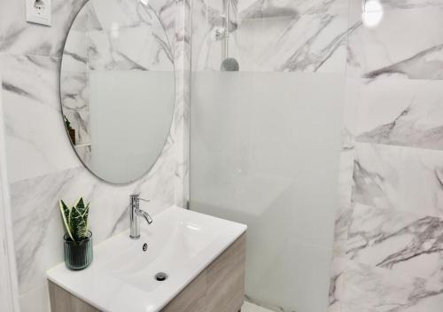 洛里什Matching Loures Guest House的白色的浴室设有水槽和镜子