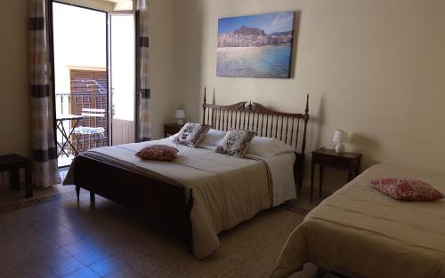 切法卢Sicilian Dream Apartments的一间带两张床的卧室和一个阳台