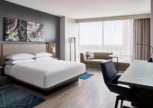 贝塞斯达贝塞斯达北万豪酒店&会议中心的一间卧室配有一张床、一张桌子和一张沙发