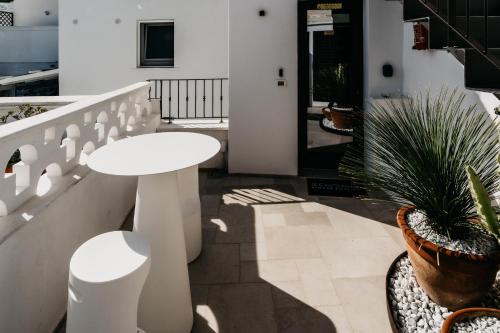 莫诺波利Le Contrade Di San Salvatore的阳台上的白色桌子和盆栽植物