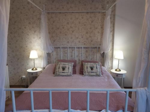 锡纳亚Apartament Dragoste și Lavandă Sinaia的一间卧室配有一张带两个枕头和两个灯的床。