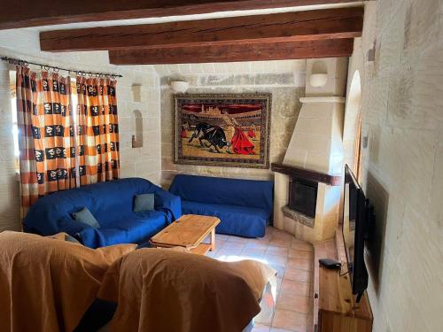 萨奈特Farmhouse with Pool, Tas-Summiena Gozo的客厅配有蓝色的沙发和电视