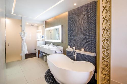 卡波圣卢卡斯Residential Retreat 2 Bedroom Suite Garza Blanca Los Cabos Resort & Spa的浴室配有大型白色浴缸和水槽