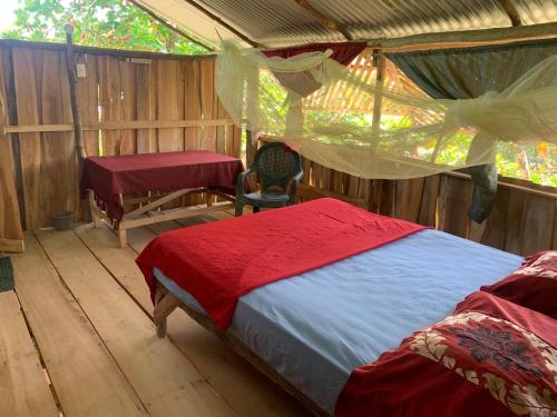 奎波斯城米格尔冲浪营地旅馆的一间帐篷内的卧室,配有一张床和一张书桌
