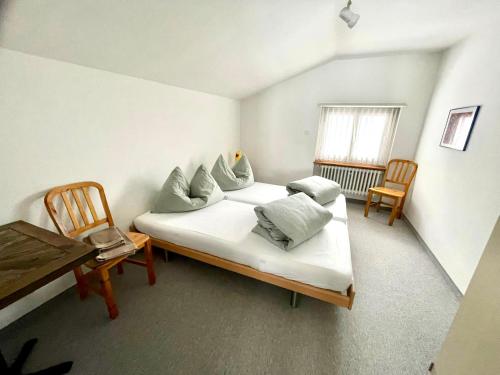 塞德龙Swiss Alpine Hideaway的配有床和两把椅子及一张桌子的房间