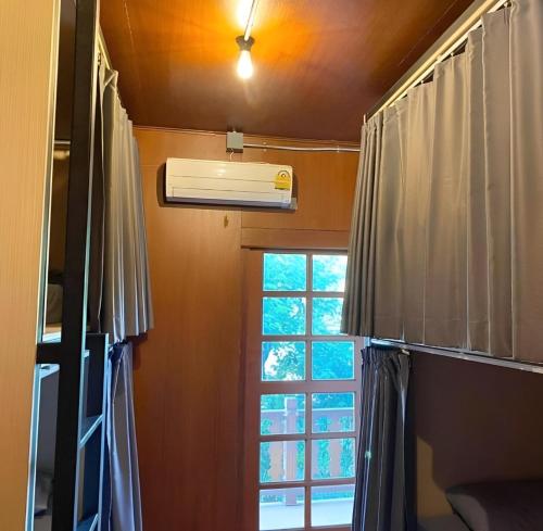 清迈Cozy Hub Hostel的客房设有窗户和空调。