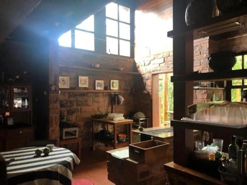 安达拉伊Pousada Casa Fraternità, viva momentos de tranquilidade em contato com a natureza.的厨房配有桌子和窗户。