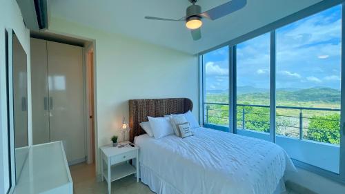 ArraijÃ¡n10G Perfect 2 Bedroom with Ocean and Jungle Views的一间卧室设有一张床和一个大窗户