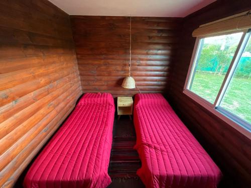 巴克罗斯La Josefina的小型客房设有2张红色的床和窗户。
