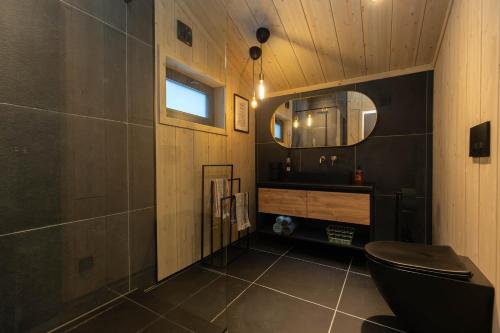 弗洛High standard cabin in a quiet area in the bossom of nature near Flå的浴室设有黑色的卫生间和镜子