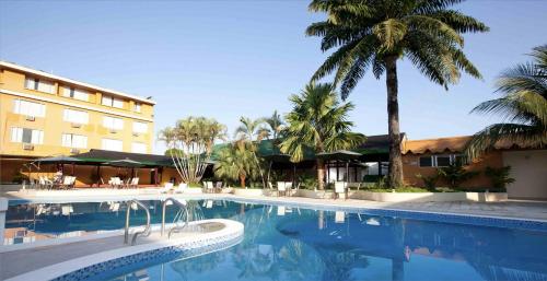 莱蒂西亚Hotel Anaconda的棕榈树酒店前的游泳池