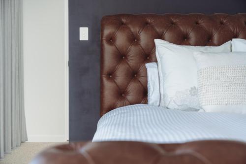 White HillsThe Cloud at Sen Vineyard的一张带棕色床头板和白色枕头的床