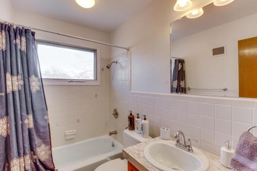 MerriamPet-Friendly Vacation Rental 10 Mi to Kansas City的带浴缸、水槽和镜子的浴室