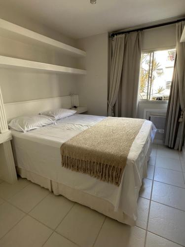 里约热内卢Apê na Gávea的卧室内的一张白色床,设有窗户