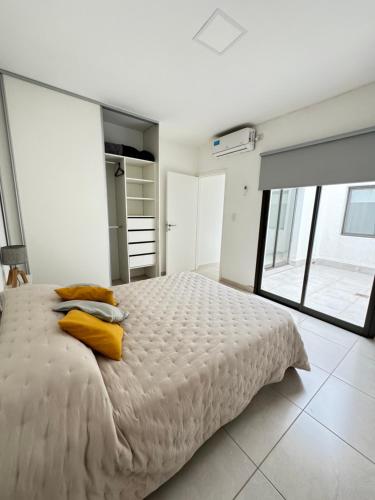 卢汉德库约Complejo Carrodilla - Lujan de Cuyo的卧室配有一张带黄色枕头的大型白色床。