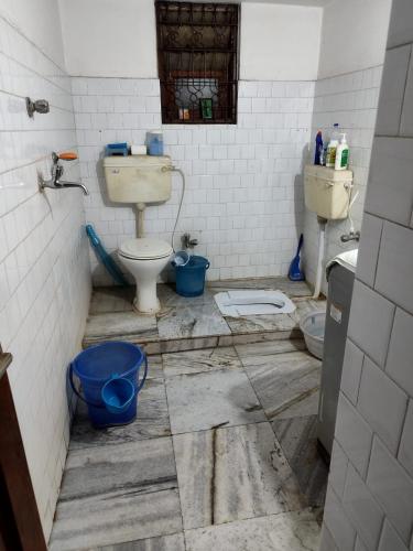布巴内什瓦尔Ashiyana的一间脏浴室,内设卫生间和两个水桶